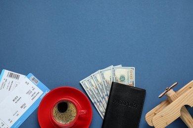 Photo of Flat lay composition with passport, dollars and tickets on blue table, space for text. Business trip