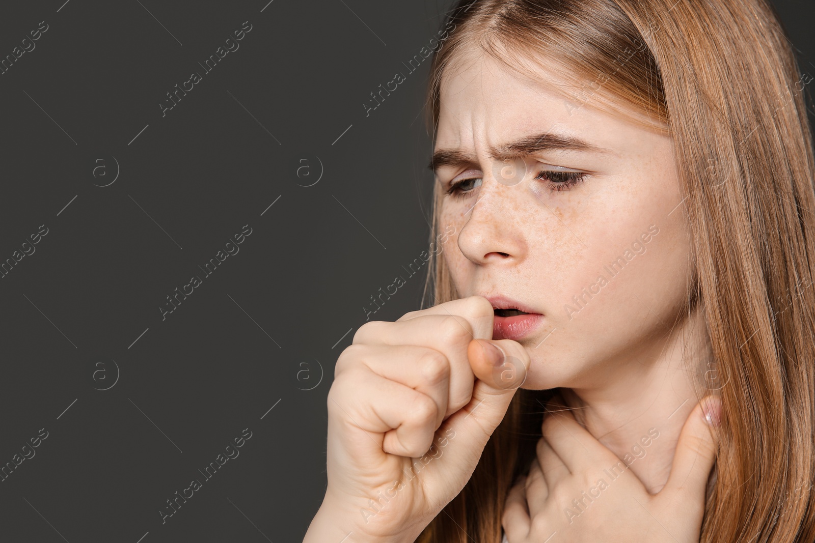 Photo of Teenage girl suffering from cough on dark background. Space for text