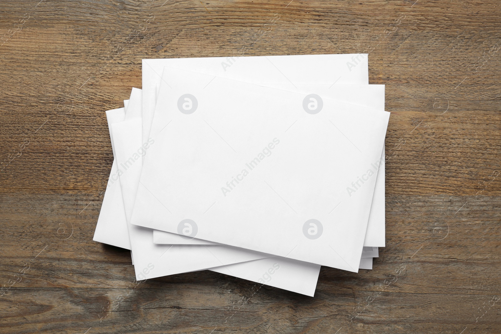 Photo of Stack of letters on wooden table, top view