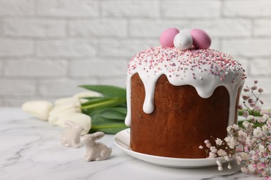 Photo of Tasty Easter cake with decorative sugar eggs and flowers on white marble table. Space for text