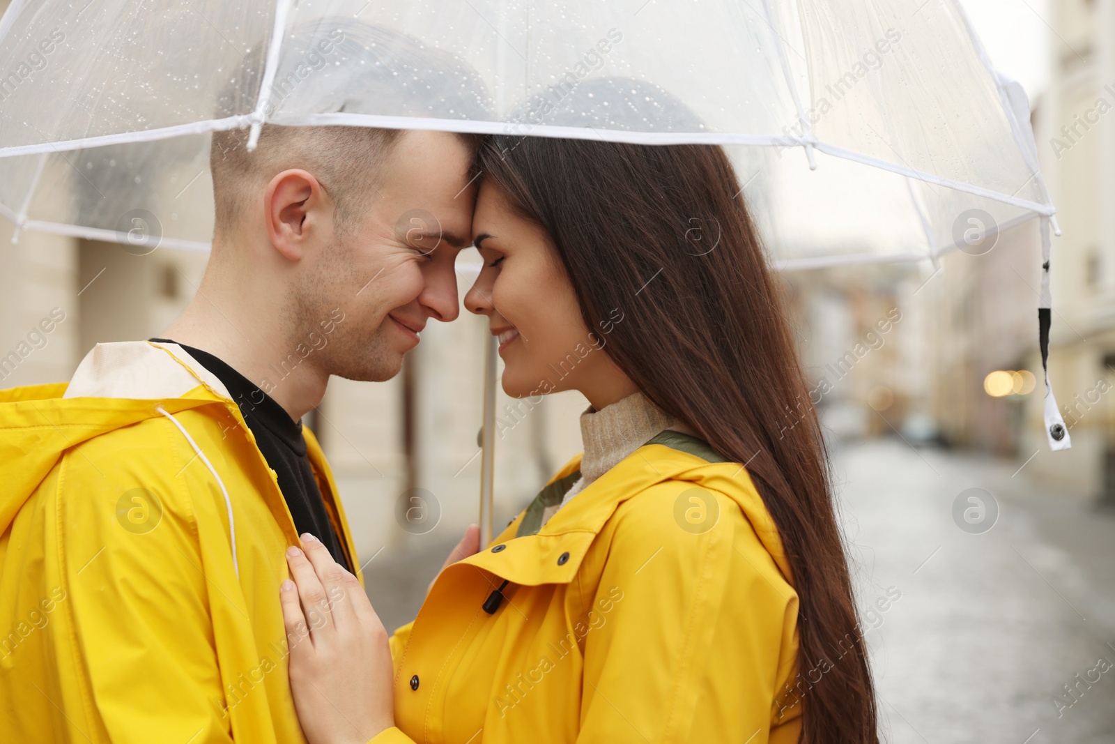 Photo of Lovely young couple with umbrella on city street