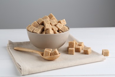 Photo of Brown sugar cubes on white wooden table