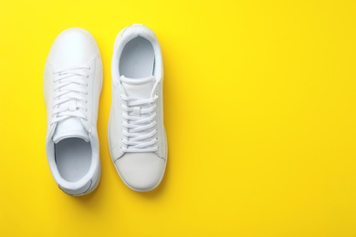 Photo of Pair of sneakers on color background, flat lay. Space for text