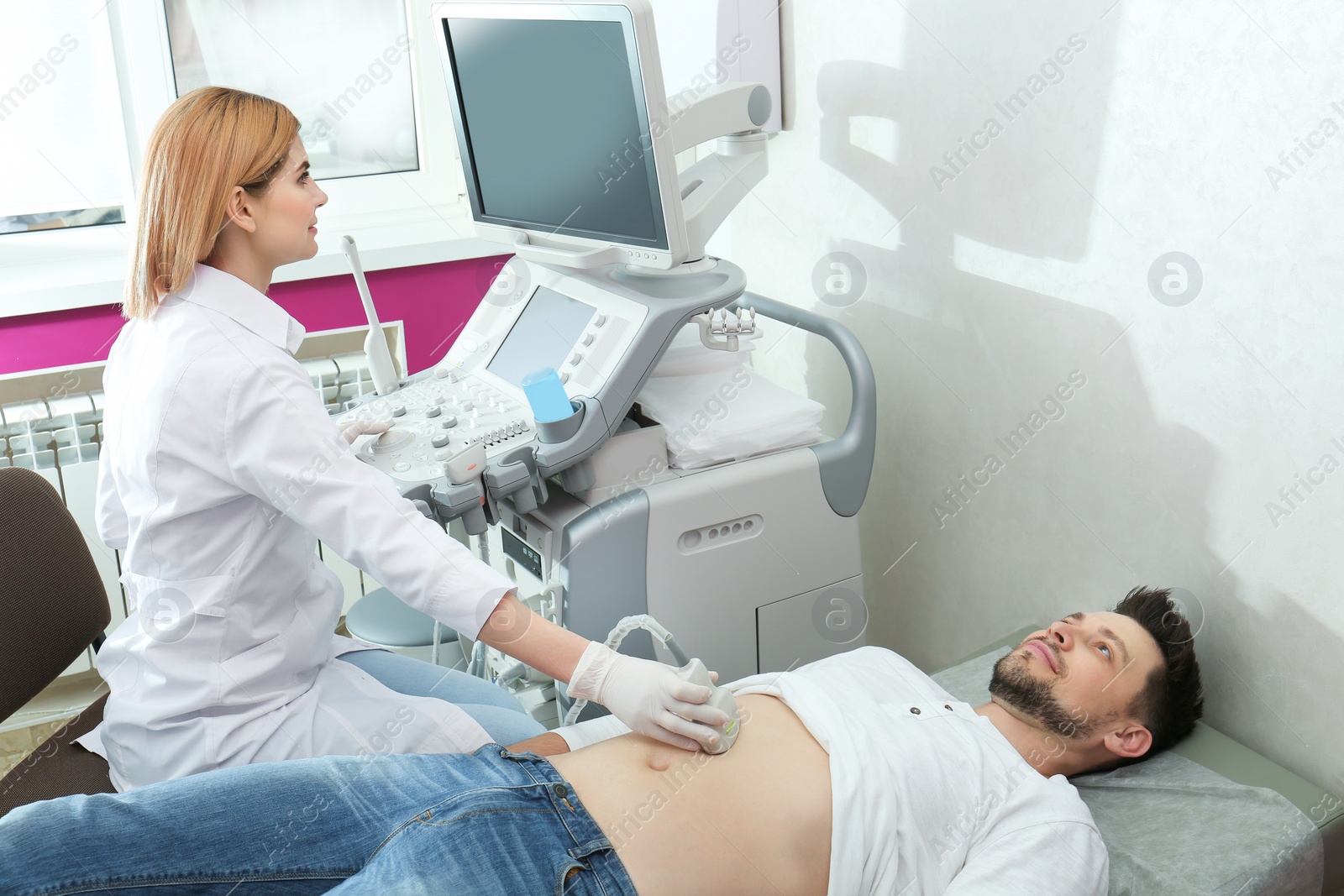 Photo of Doctor conducting ultrasound examination of internal organs in clinic. Space for text