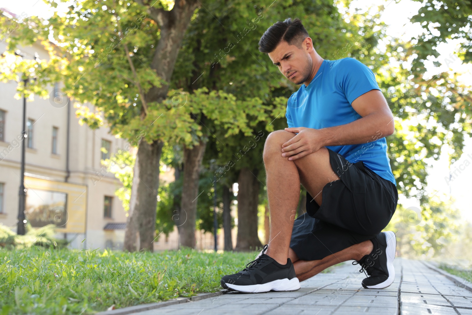 Photo of Man in sportswear having knee problems outdoors