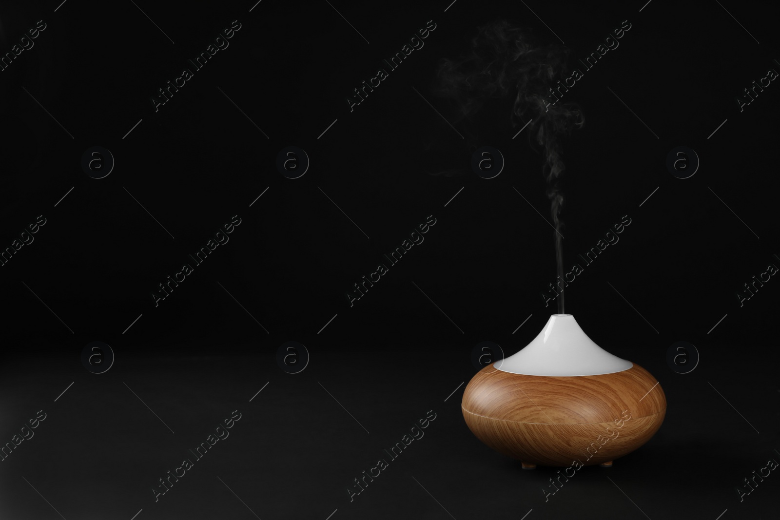 Photo of Aroma oil diffuser on black background. Air freshening