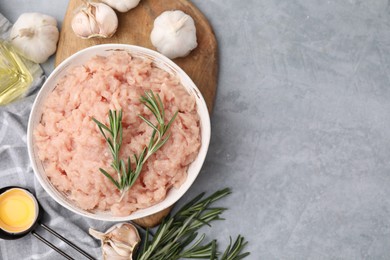 Photo of Flat lay composition with fresh raw minced meat and rosemary on light grey table. Space for text