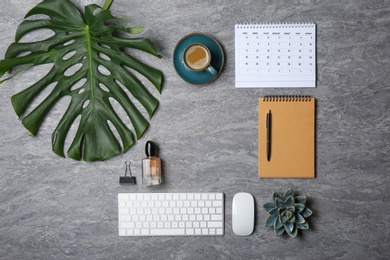 Photo of Flat lay composition with cup of coffee and office accessories on grey background