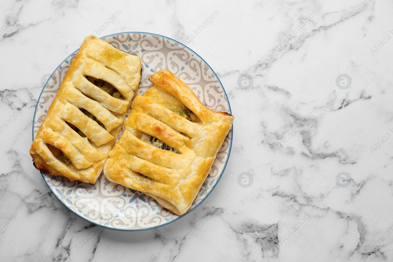 Photo of Fresh tasty puff pastry with kiwi on white marble table, top view. Space for text