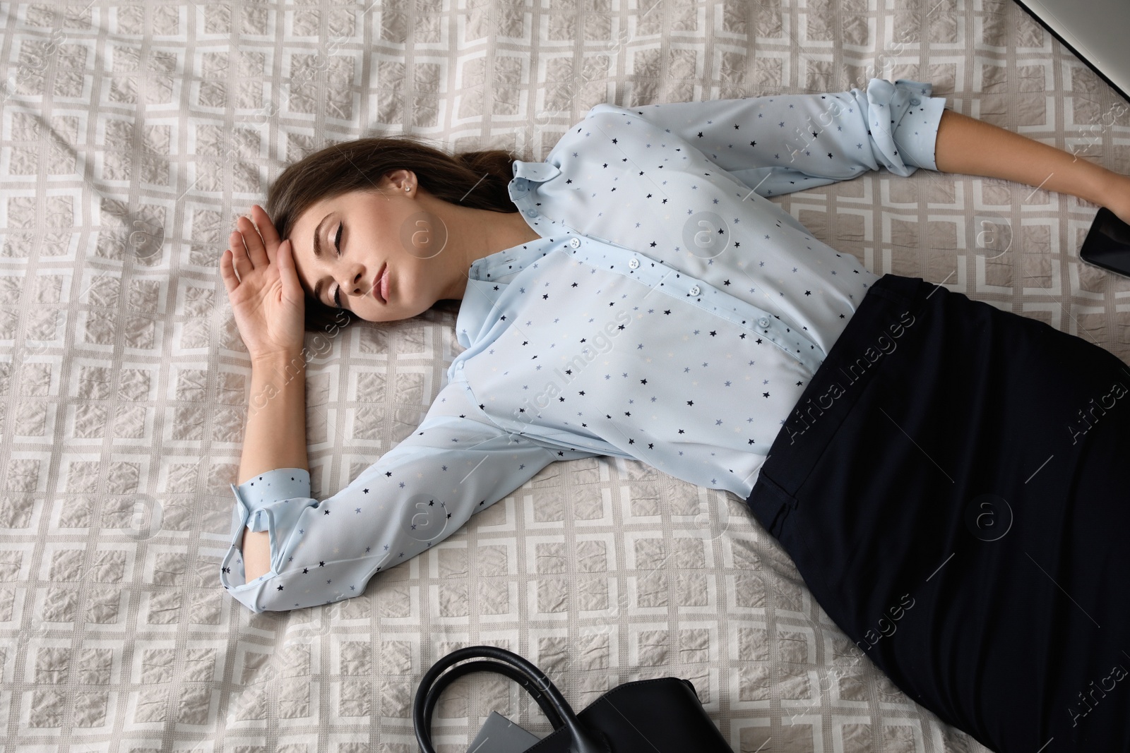 Photo of Exhausted businesswoman in office wear sleeping on bed at home after work, above view