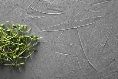 Photo of Food photography. Fresh microgreens on grey textured table, flat lay with space for text