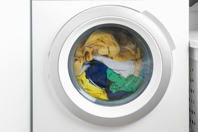 Washing machine with clothes, closeup. Laundry day