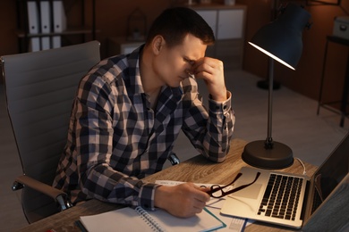 Overworked man with headache in office