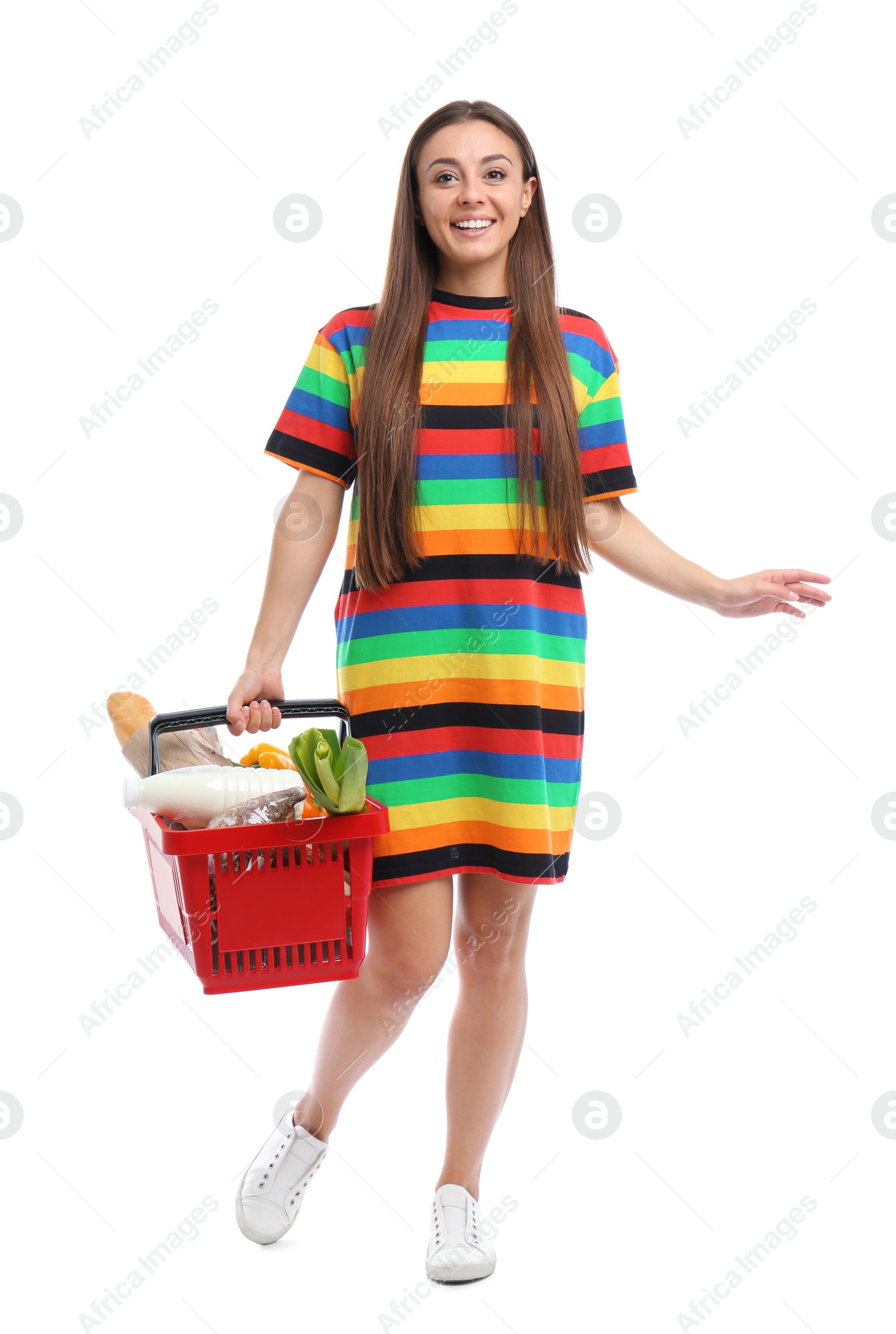 Photo of Young woman with shopping basket full of products isolated on white