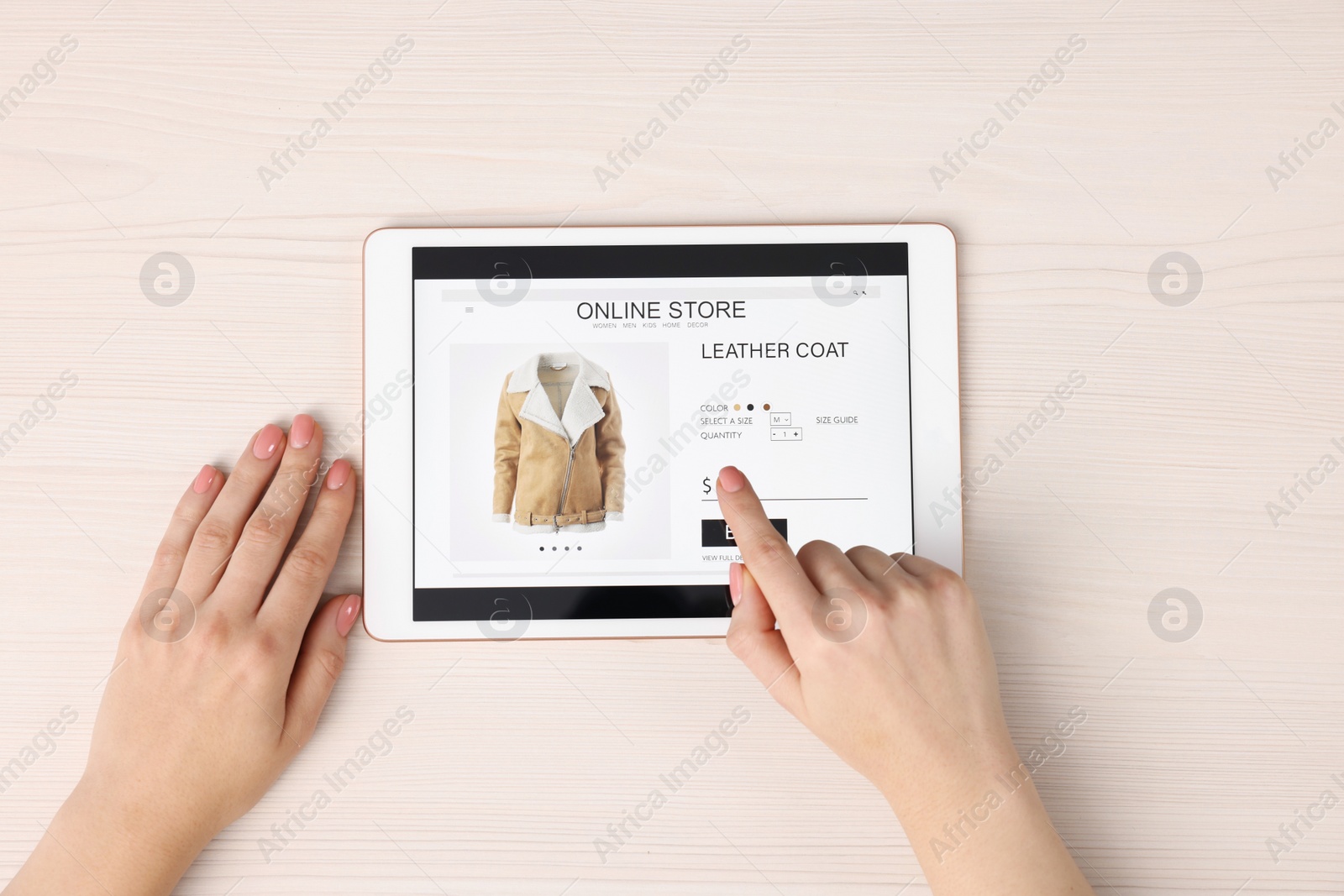 Photo of Woman with tablet shopping online at white wooden table, top view