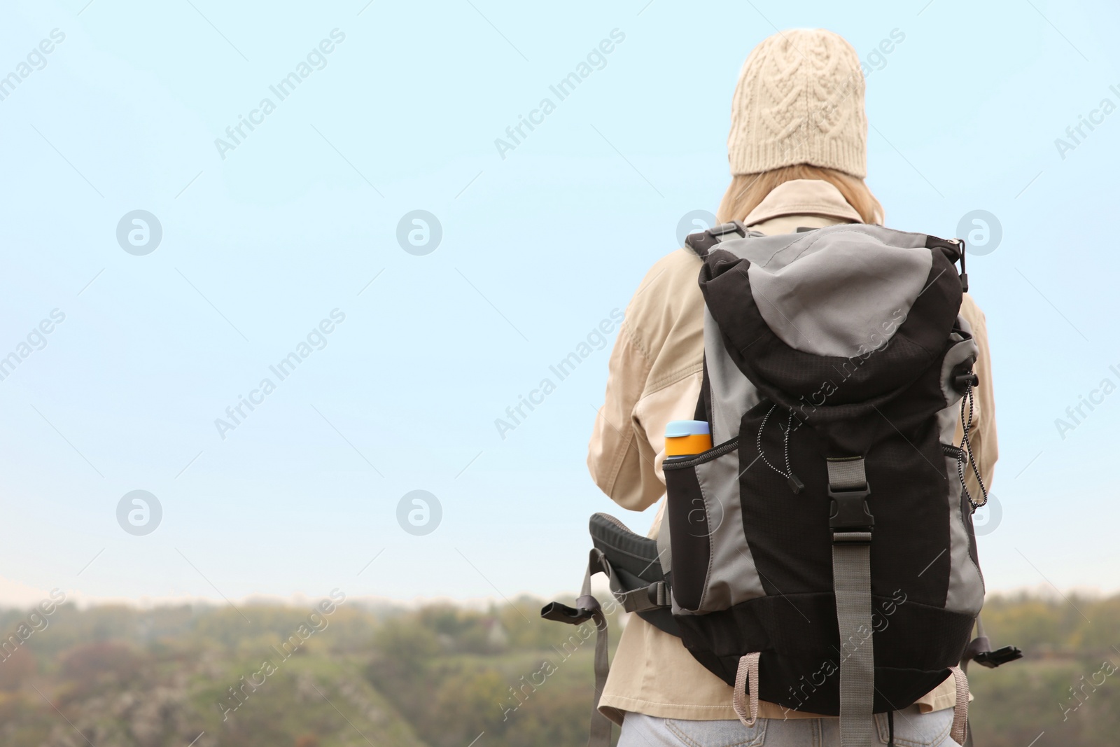 Photo of Traveler with backpack enjoying beautiful view on sunny day. Autumn vacation