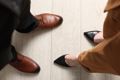 Businessman and businesswoman in elegant shoes on floor, above view