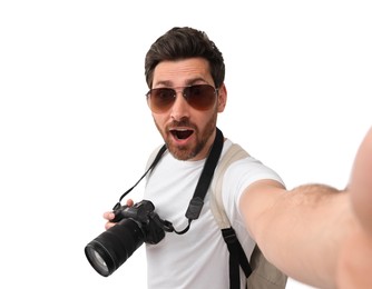 Smiling man with camera taking selfie on white background