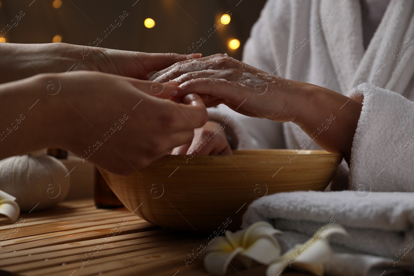 Photo of Woman receiving hand treatment at table in spa, closeup