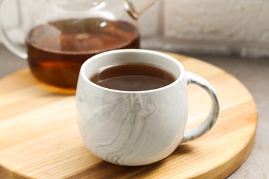 Photo of Aromatic tea in cup and glass teapot on table, closeup