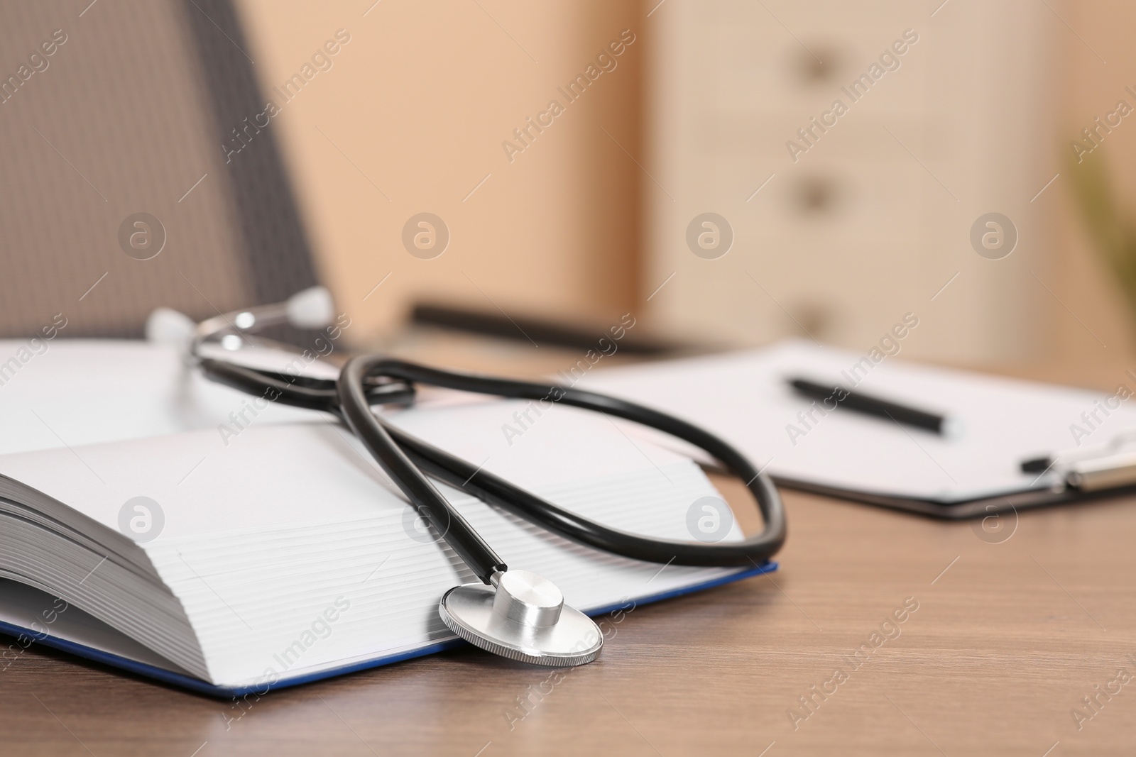 Photo of Book and stethoscope on wooden table indoors, space for text. Doctor education