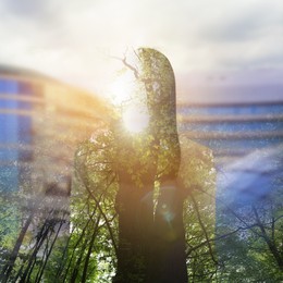 Double exposure of woman and green trees in city