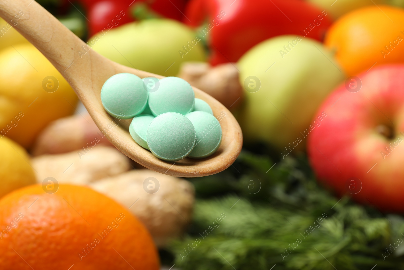 Photo of Dietary supplements in wooden spoon near products, closeup. Space for text