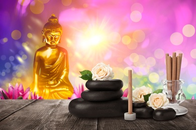 Composition with incense sticks on wooden table and Buddha figure on background