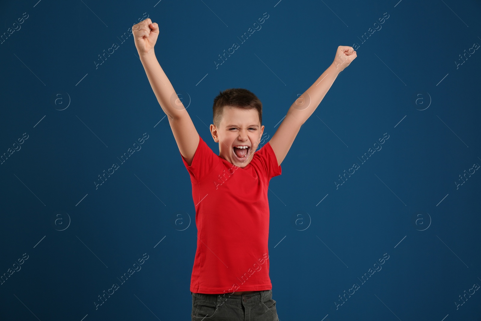 Photo of Portrait of emotional preteen boy on blue background