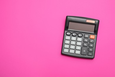 Calculator on pink background, top view. Space for text