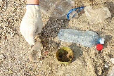Photo of Woman in gloves collecting garbage on beach, above view