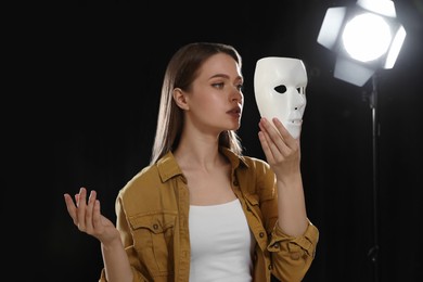 Professional actress rehearsing with mask on stage in theatre