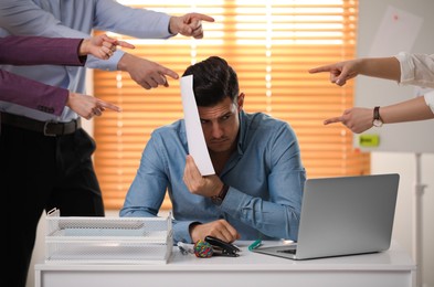Photo of Coworkers bullying their colleague at workplace in office