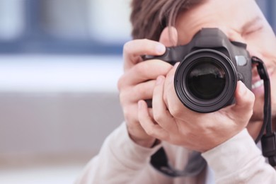 Image of Professional photographer with camera on blurred background. Space for text