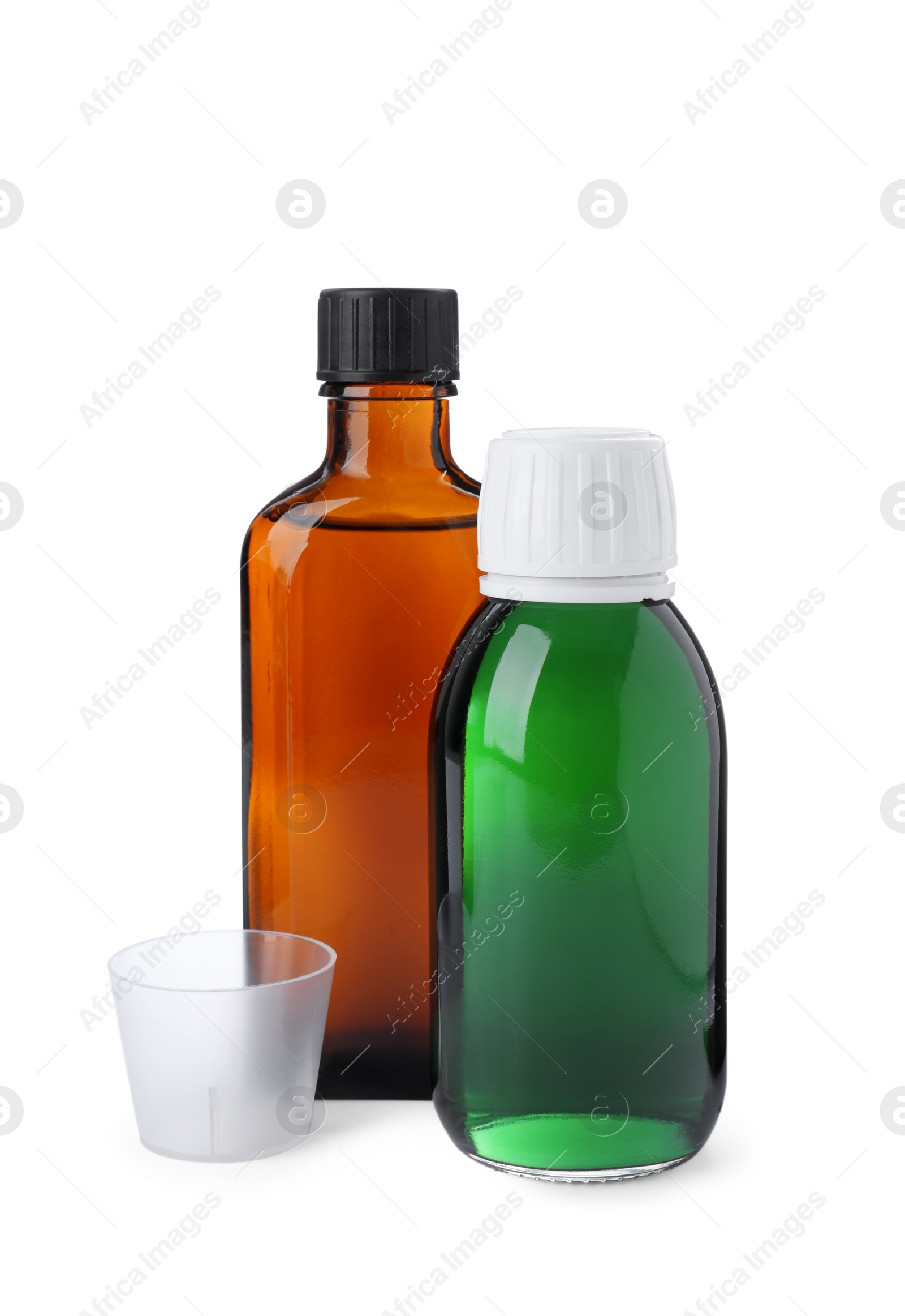 Photo of Bottles of syrups with measuring cup on white background. Cough and cold medicine