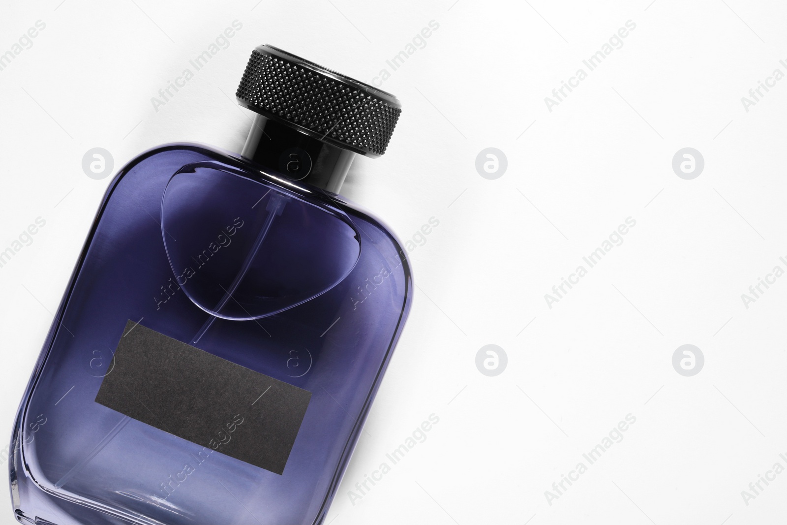 Photo of Luxury men`s perfume in bottle on white background, top view. Space for text