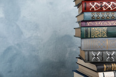 Photo of Stack of hardcover books on light blue background, closeup. Space for text