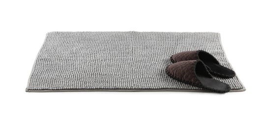 Photo of New grey bath mat with soft slippers isolated on white