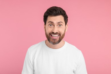 Photo of Portrait of happy surprised man on pink background