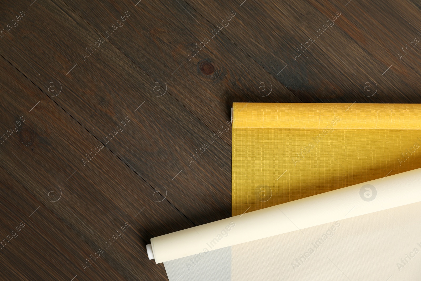 Photo of Stylish roller window blinds on wooden table, flat lay. Space for text