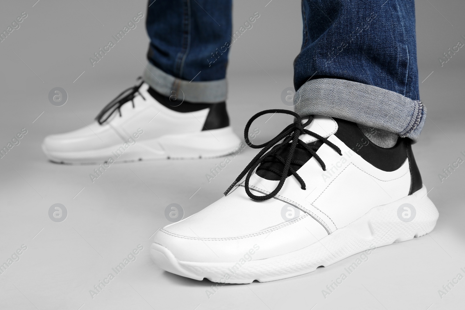 Photo of Man in stylish sport shoes on light background