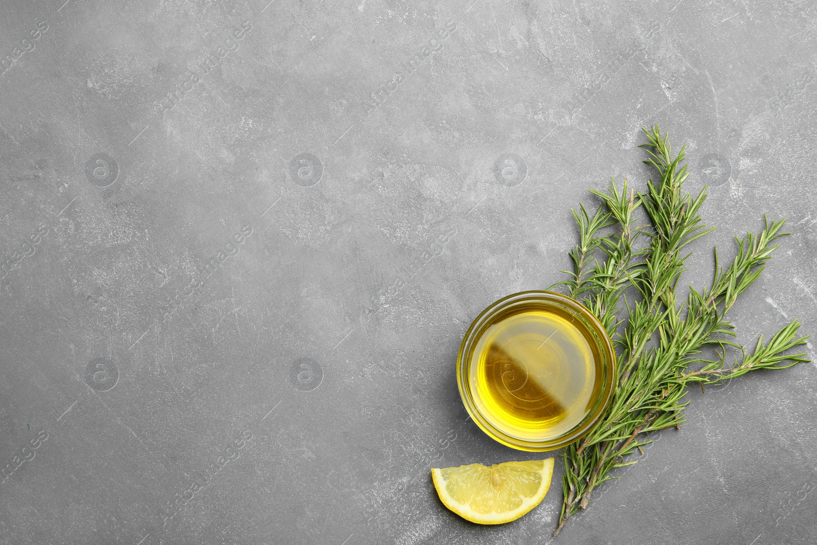 Photo of Flat lay composition with fresh rosemary oil on grey background