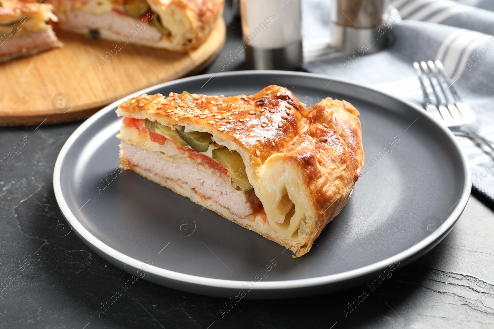 Photo of Piece of tasty homemade pie with filling on dark grey table