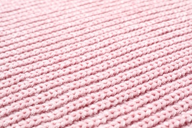 Pink winter sweater as background, closeup view