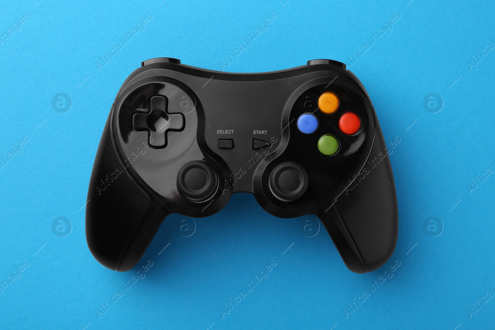 Photo of Wireless game controller on light blue background, top view