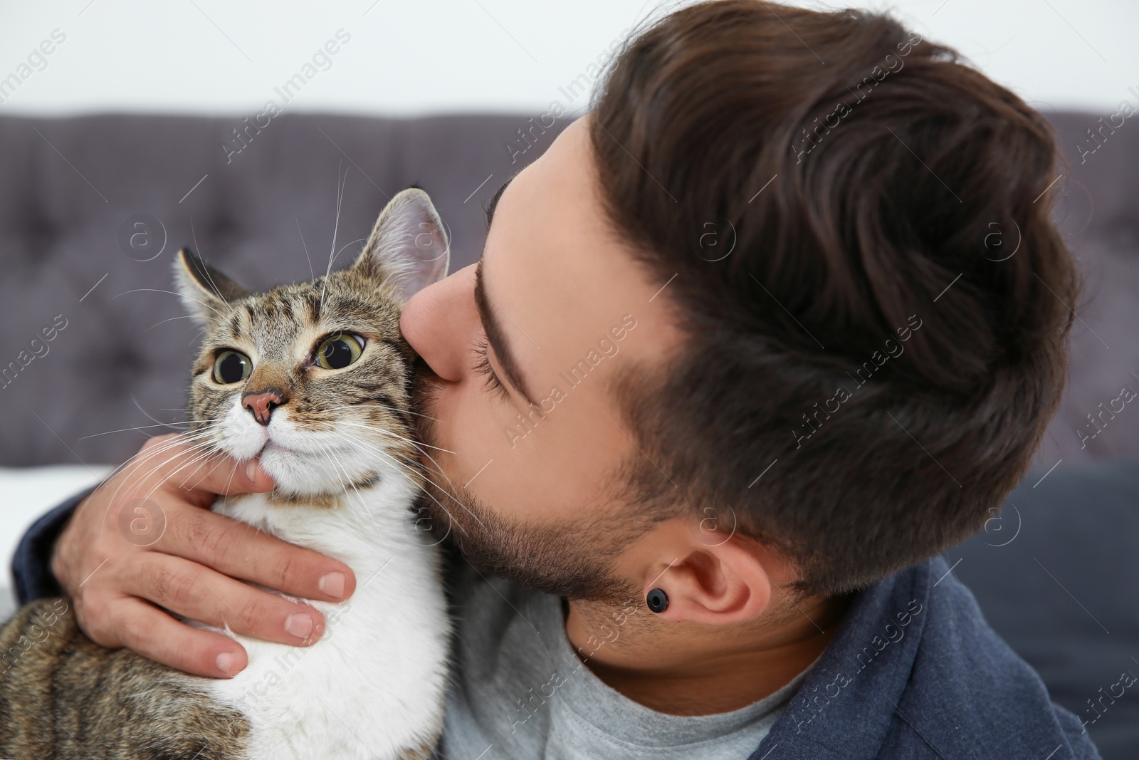 Photo of Happy man with cat at home. Friendly pet