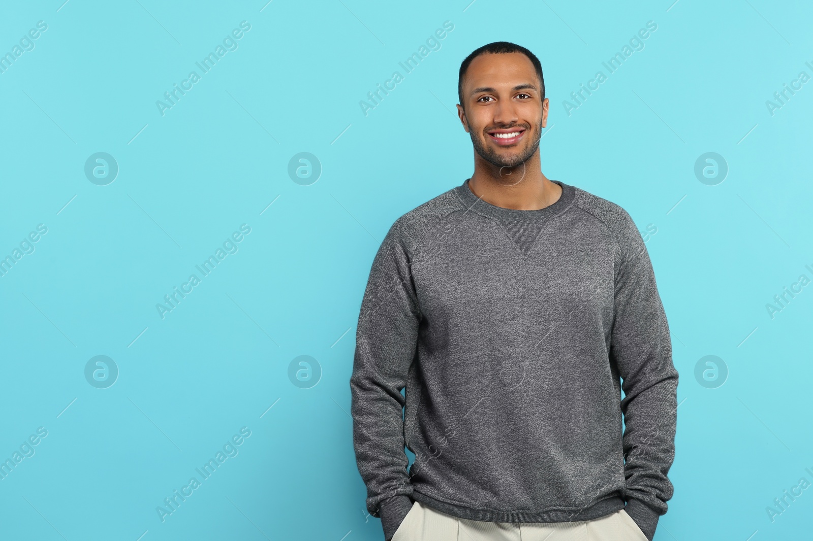 Photo of Portrait of handsome young man on light blue background, space for text
