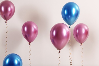 Photo of Color balloons with ribbons on white background