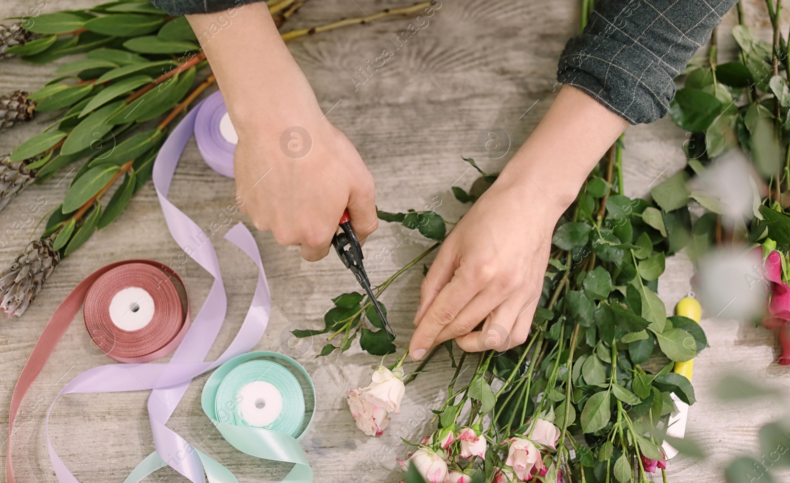 Photo of Male florist making beautiful bouquet in flower shop, closeup