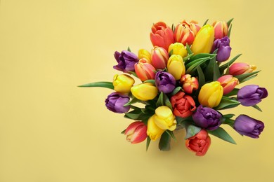 Photo of Bouquet of beautiful tulips on beige background, top view. Space for text